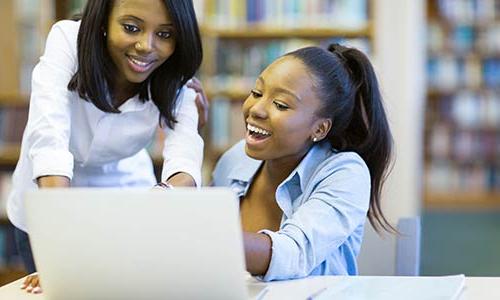 two diverse students looking at computer 